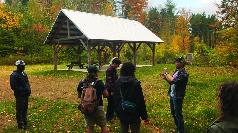Students and faculty outside in the forest at Glover Ledge